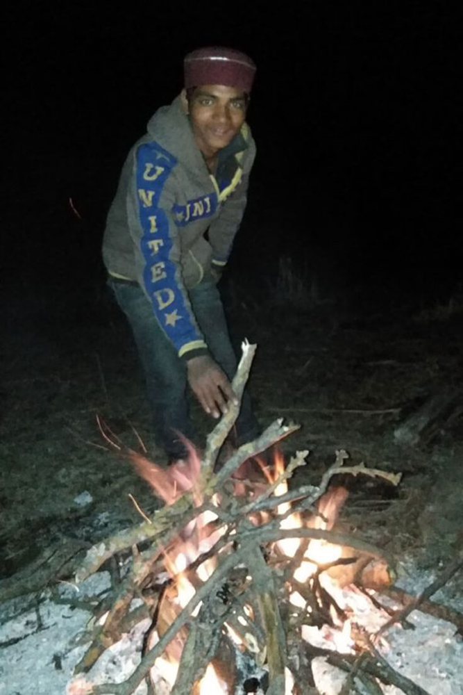 Guide Laxman adding wood to the fire at the Indian Igloo