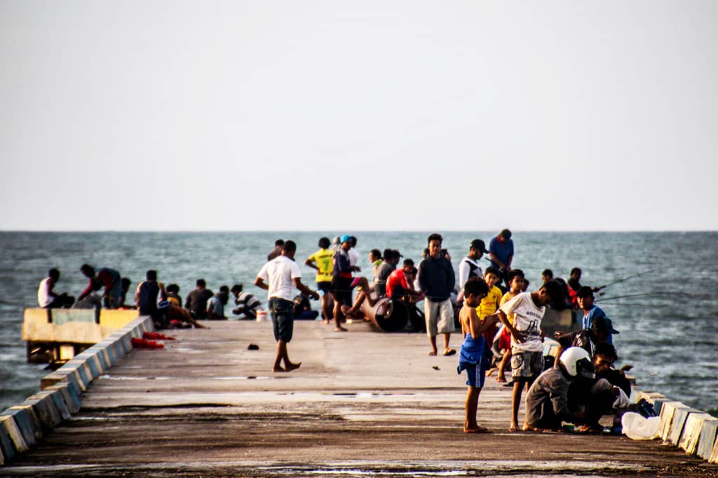 Locals fishing off the pier in Kupang, Indonesia